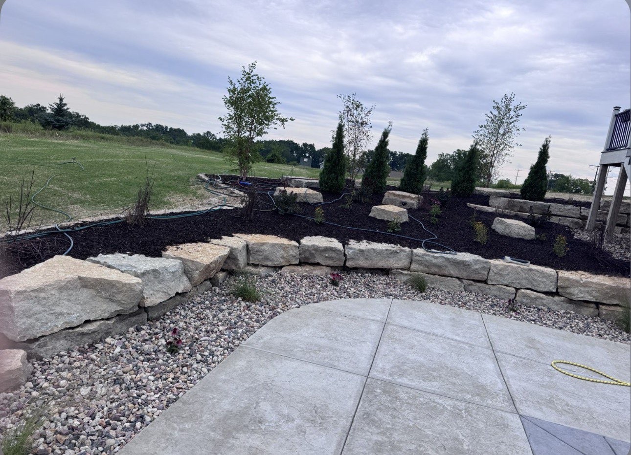 Boulder retaining wall and planting beds