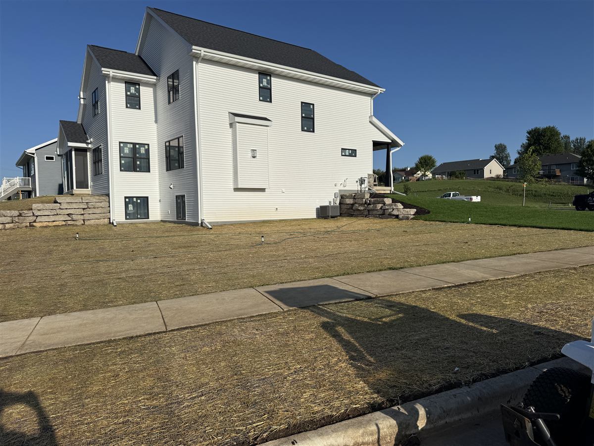 Tiered stone retaining wall with a fresh lawn